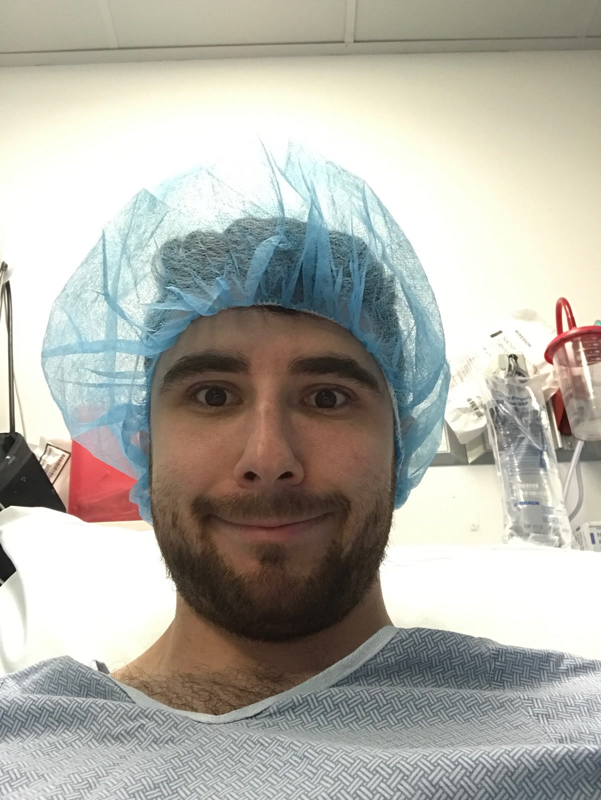 Selfie in a hospital cap and gown, smiling anyway